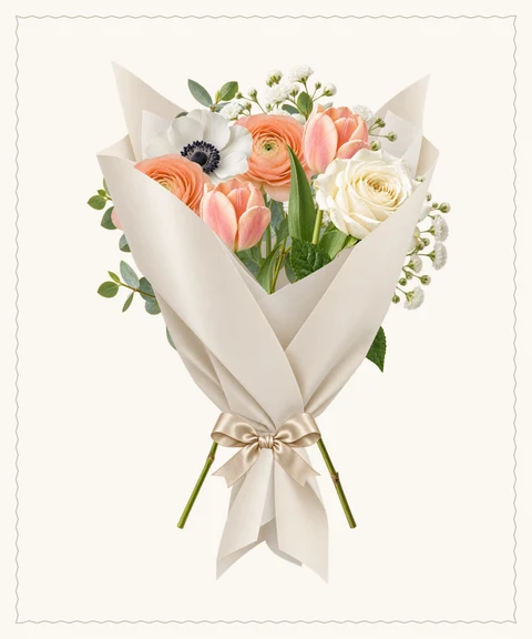 Peach ranunculus, anemones and tulips in sculpted ivory paper.